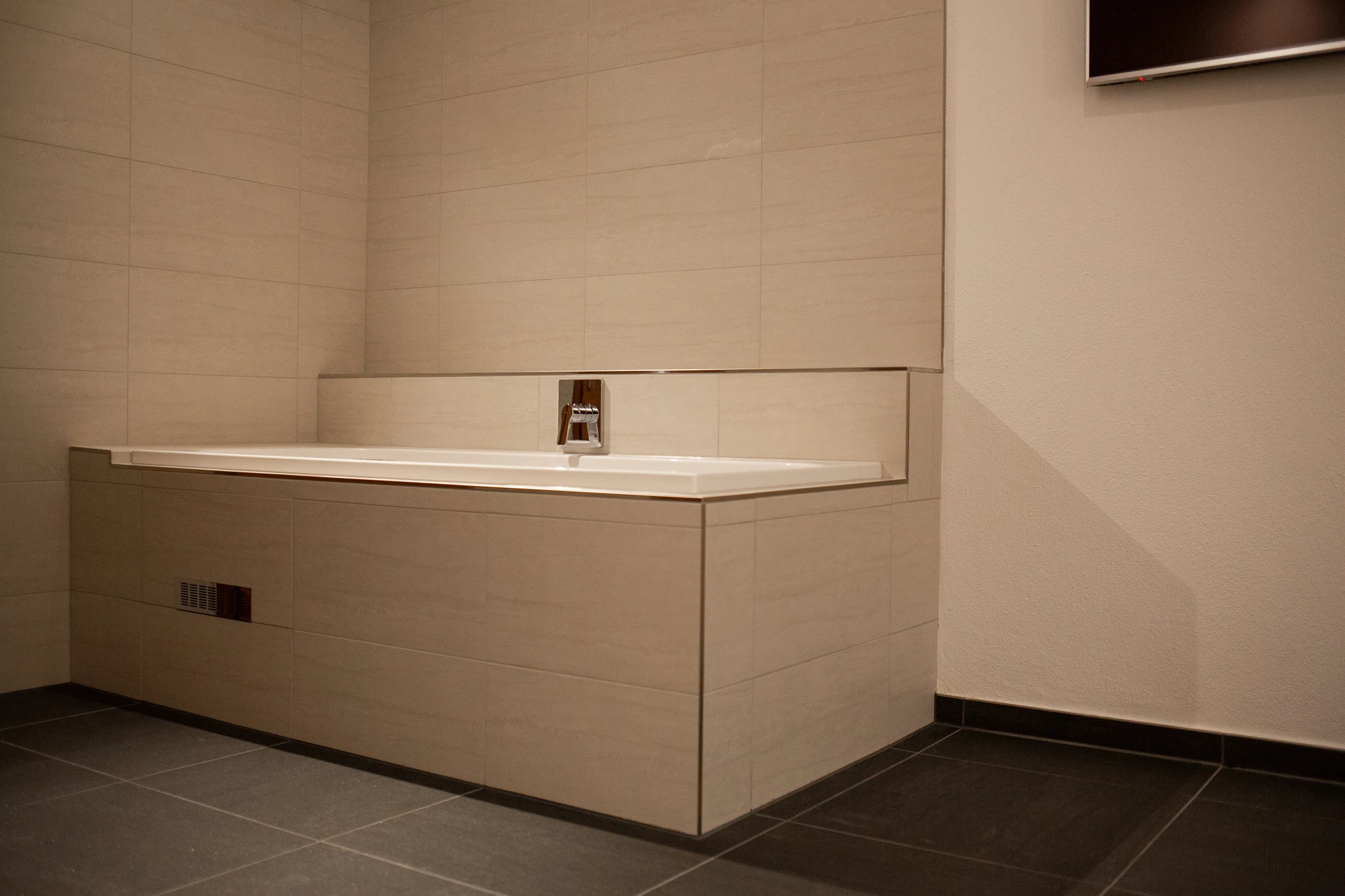 Airpool-Wanne mit verchromter Armatur und heller Fliesenverkleidung