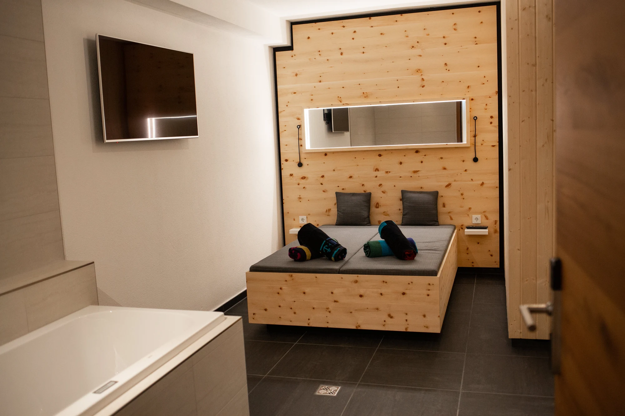 Das private SPA mit Airpool-Wanne und Liegefläche vor der Zirbenwand